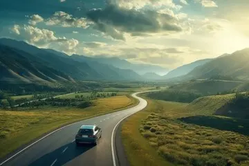 Car driving through a mountainous landscape, illustrating the peace of mind provided by exclusionary vehicle service protection when traveling far from home.