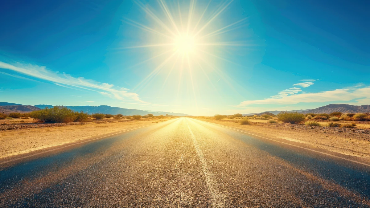 Blazing sun over empty desert highway. Keep your car cooler with these tips.