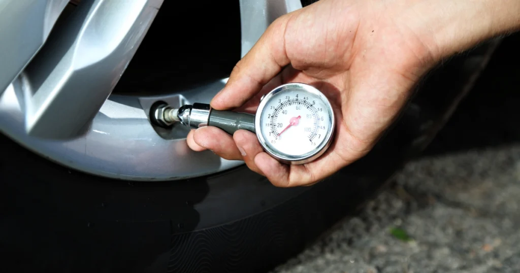 A tire pressure gauge being used for monthly car maintenance