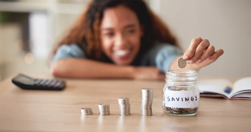 vehicle service protection saves money: a smiling woman adding a coin to a jar labeled Savings beside rising stacks of coins